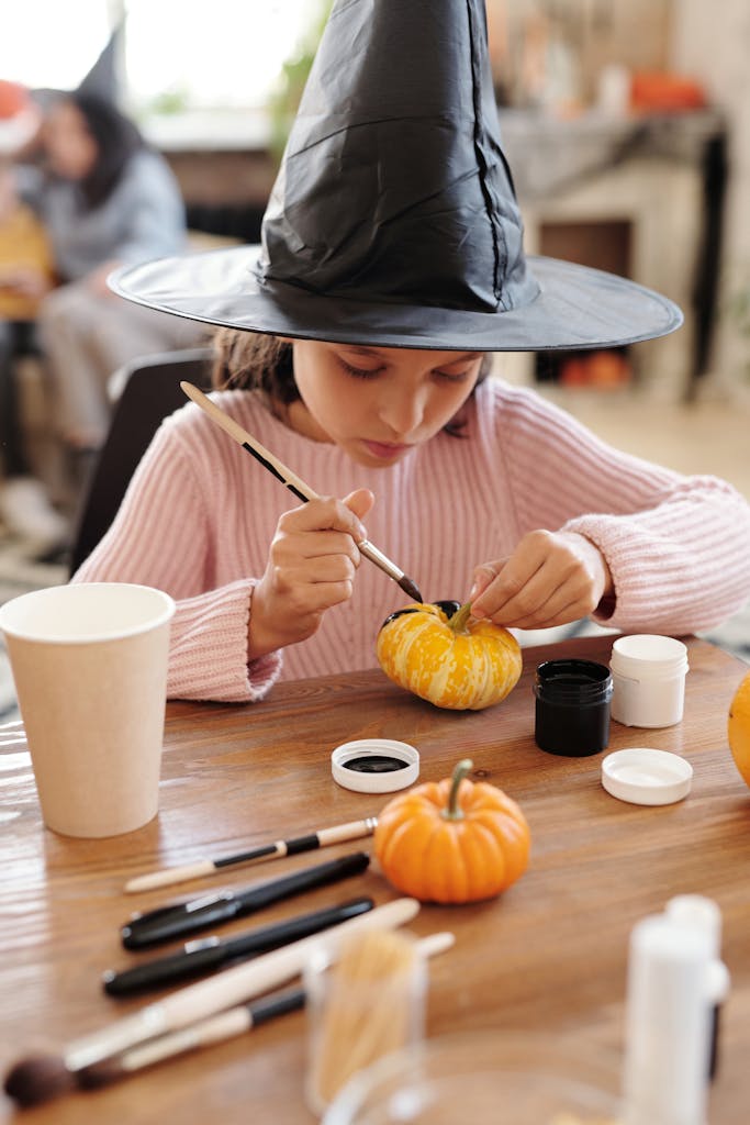 Girl in Pink Painting A Pumpkin